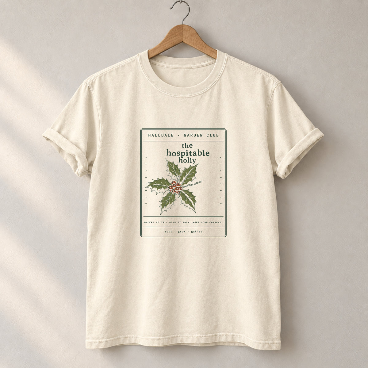 The Hospitable Holly tee in Ivory, on a hanger