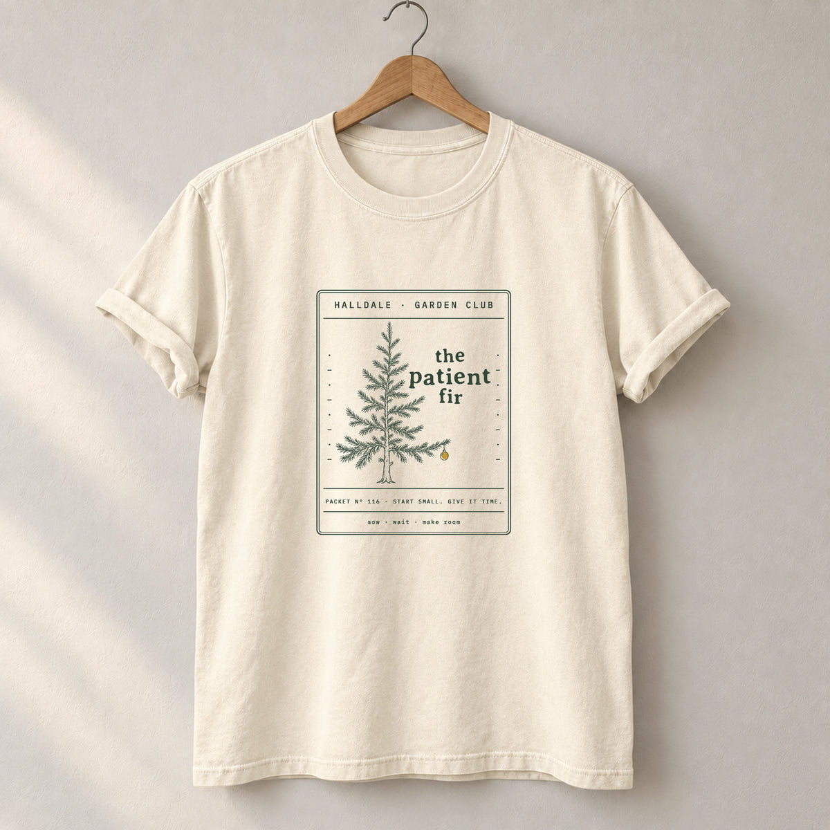 The Patient Fir tee in Ivory, on a hanger