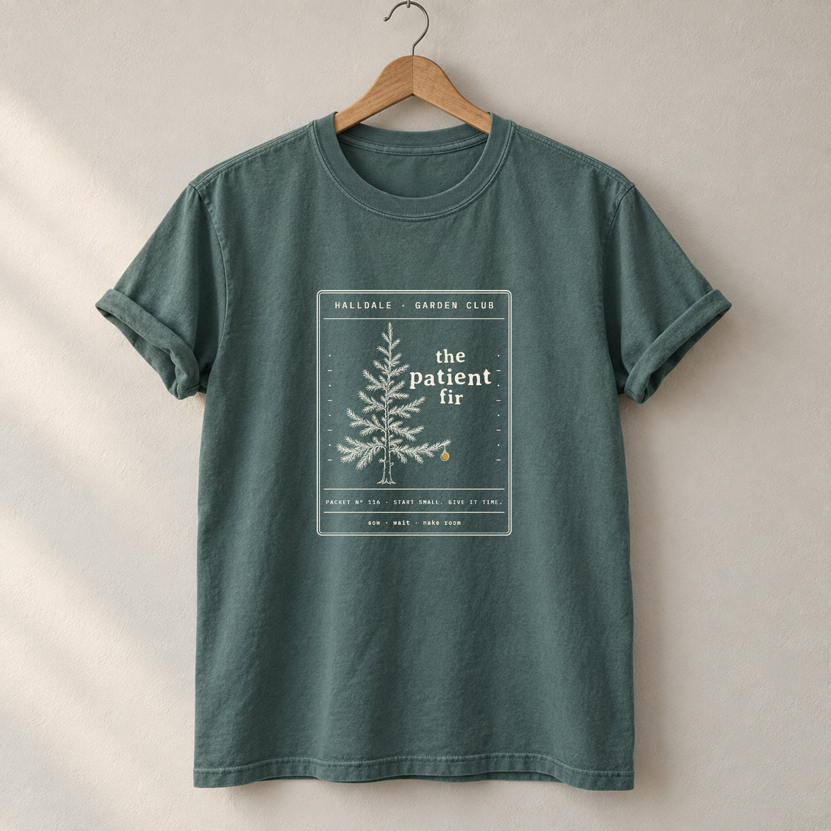 The Patient Fir tee in Blue Spruce, on a hanger