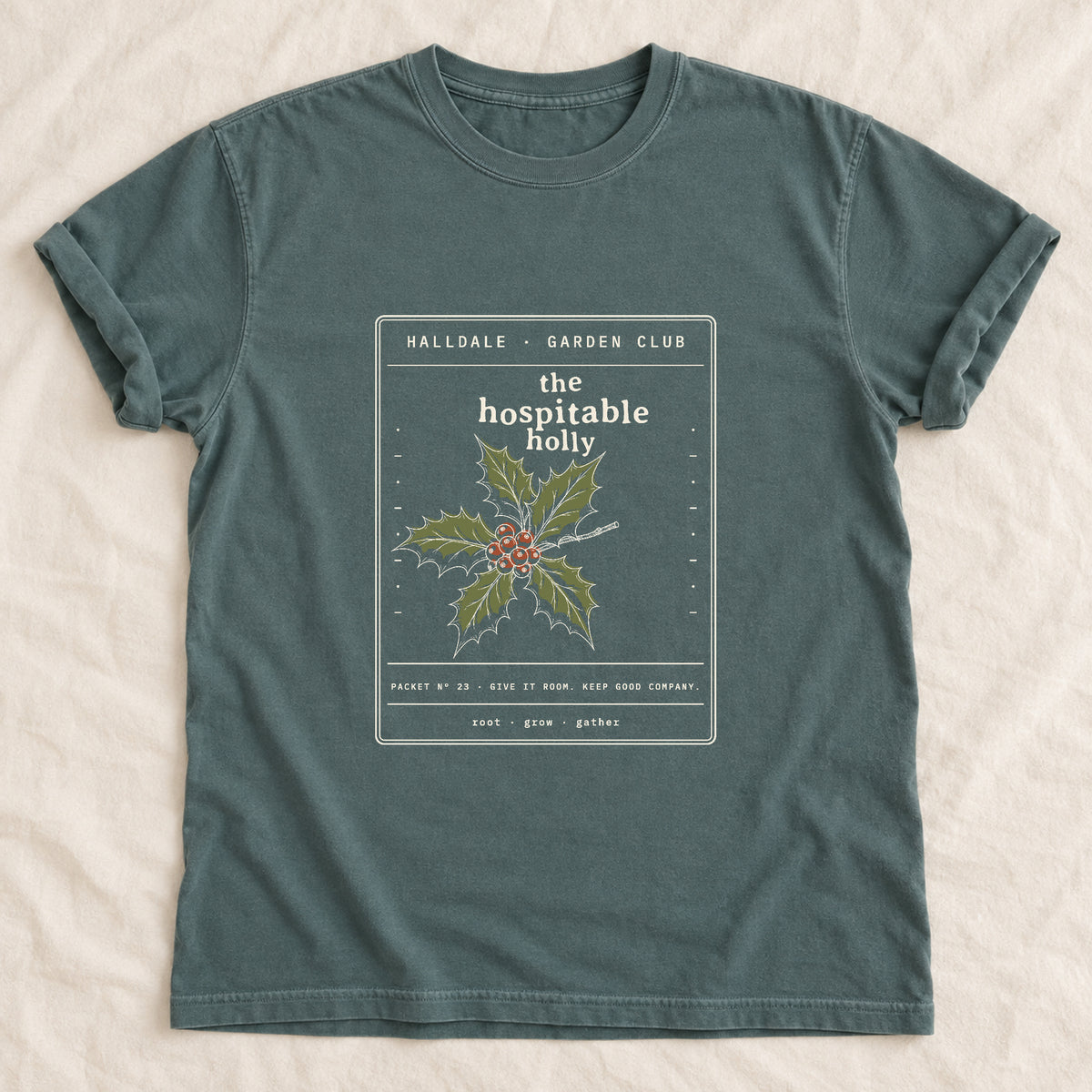 The Hospitable Holly tee in Blue Spruce, laid flat