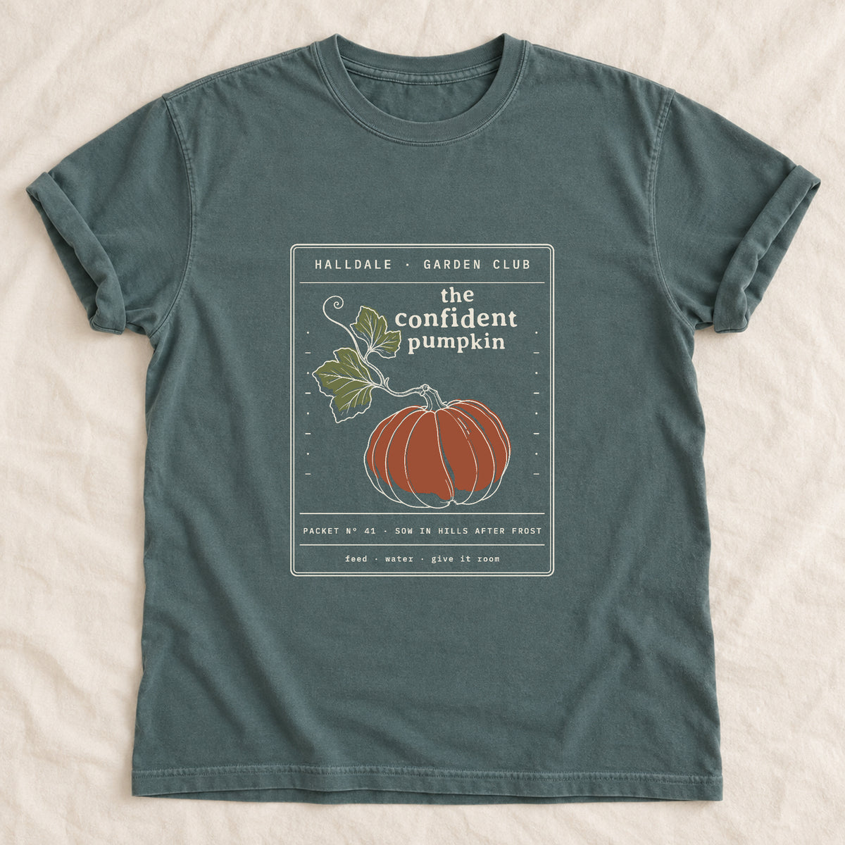 The Confident Pumpkin tee in Blue Spruce, laid flat