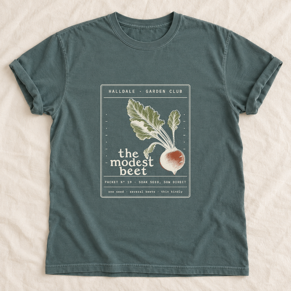 The Modest Beet tee in Blue Spruce, laid flat