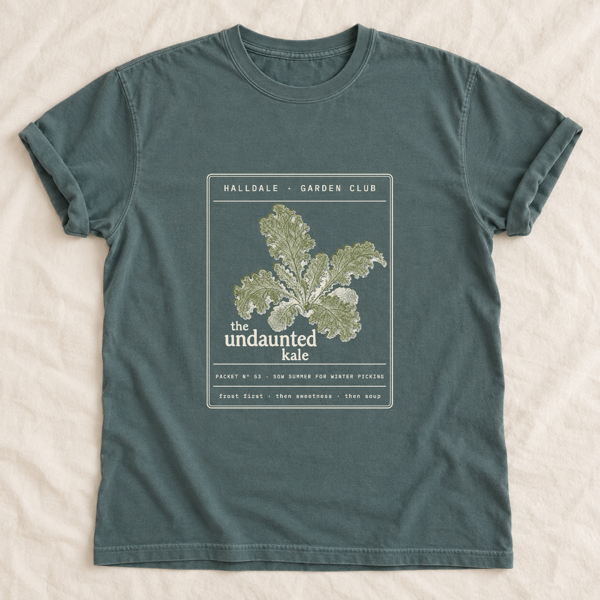 The Undaunted Kale tee in Blue Spruce, laid flat
