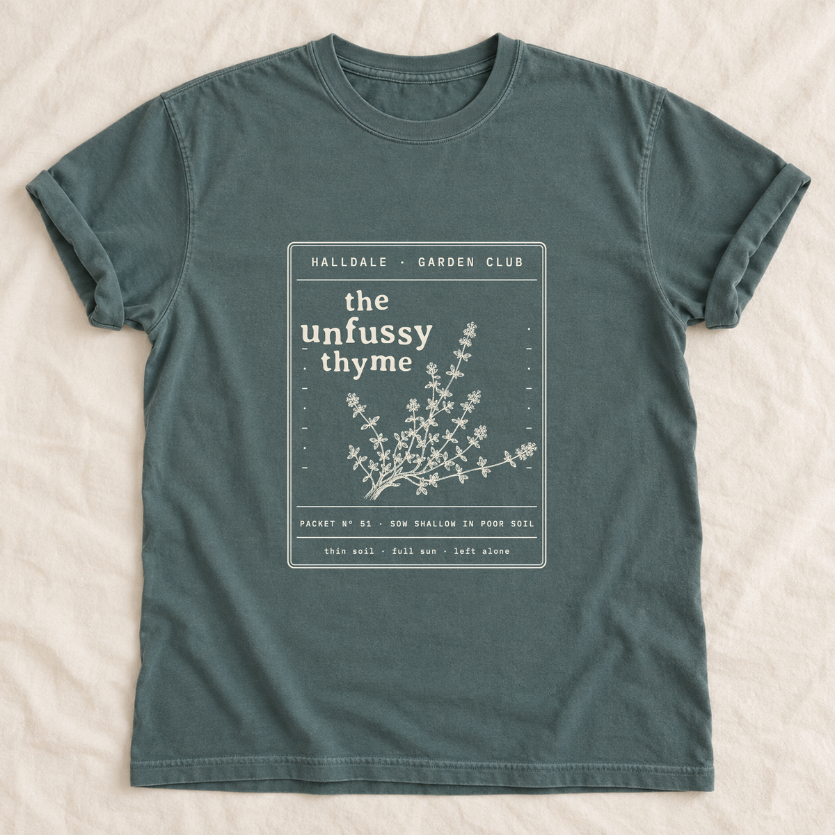 The Unfussy Thyme tee in Blue Spruce, laid flat
