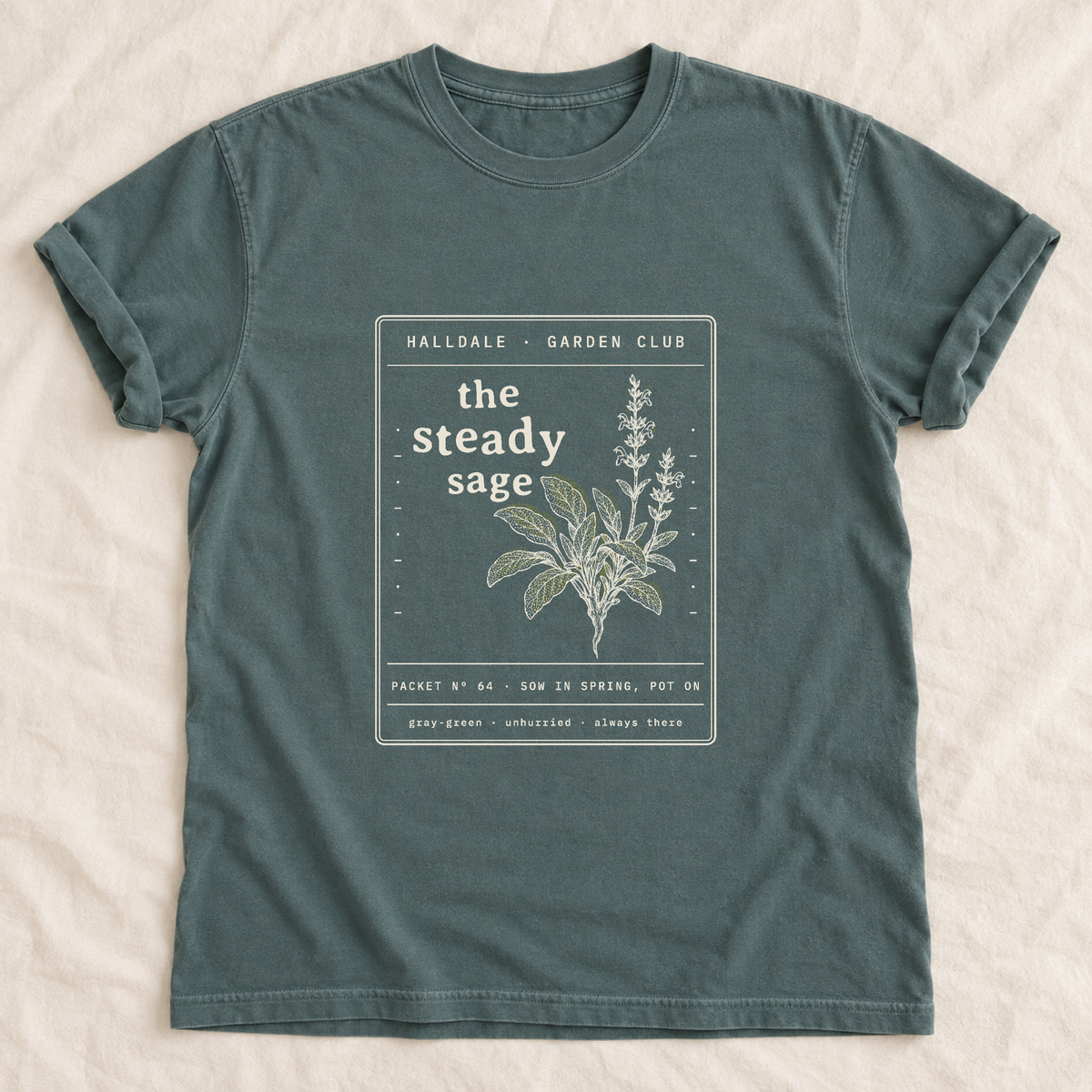 The Steady Sage tee in Blue Spruce, laid flat