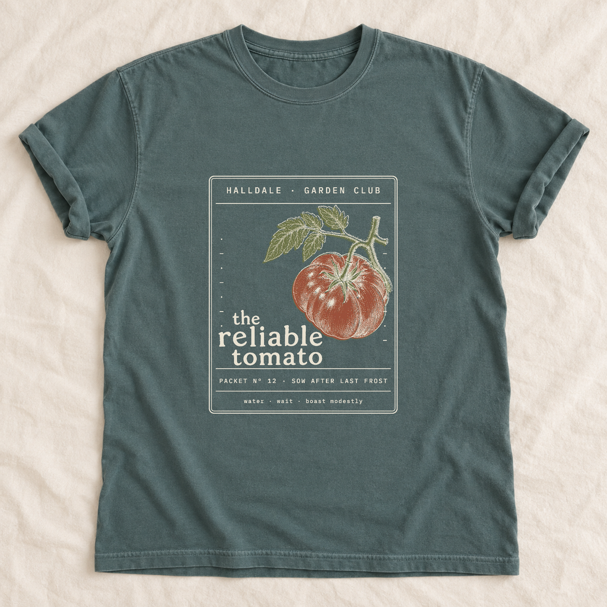 The Reliable Tomato tee in Blue Spruce, laid flat