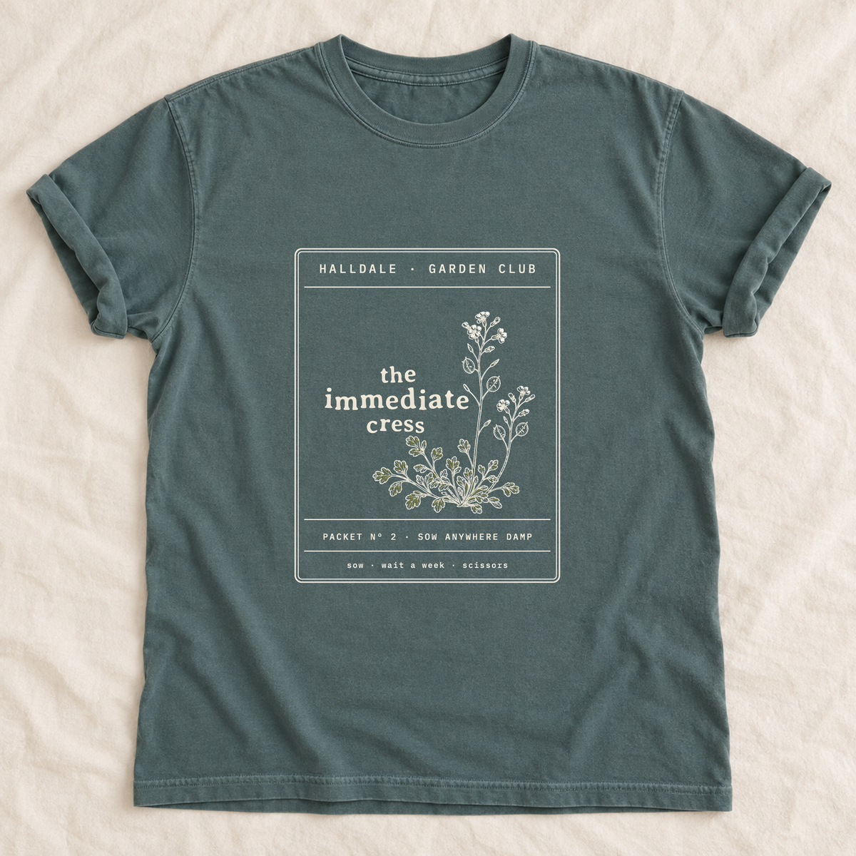 The Immediate Cress tee in Blue Spruce, laid flat