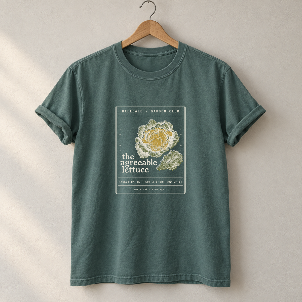 The Agreeable Lettuce tee in Blue Spruce, on a hanger
