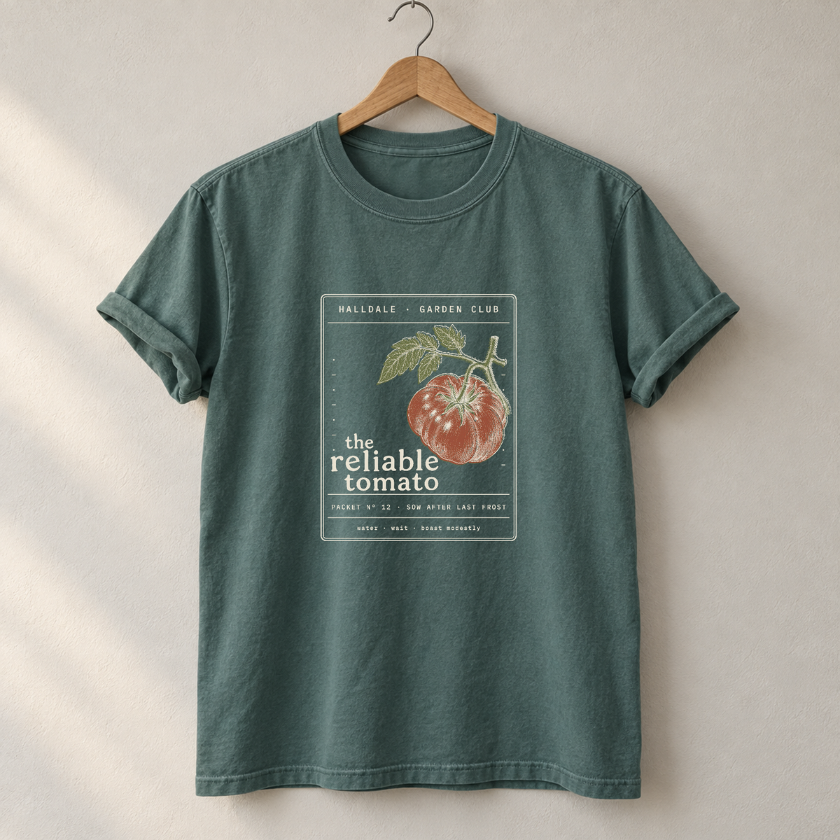 The Reliable Tomato tee in Blue Spruce, on a hanger