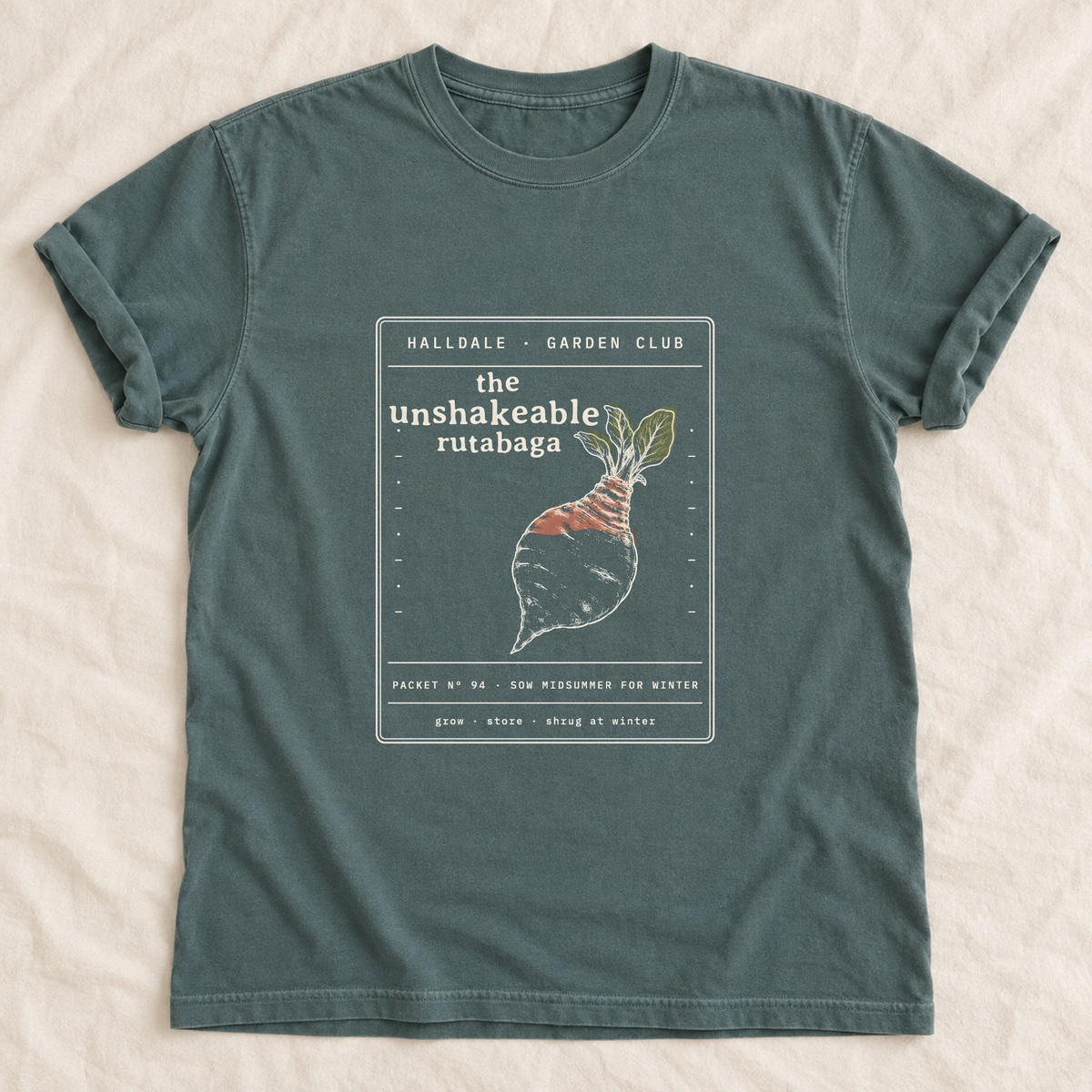 The Unshakeable Rutabaga tee in Blue Spruce, laid flat