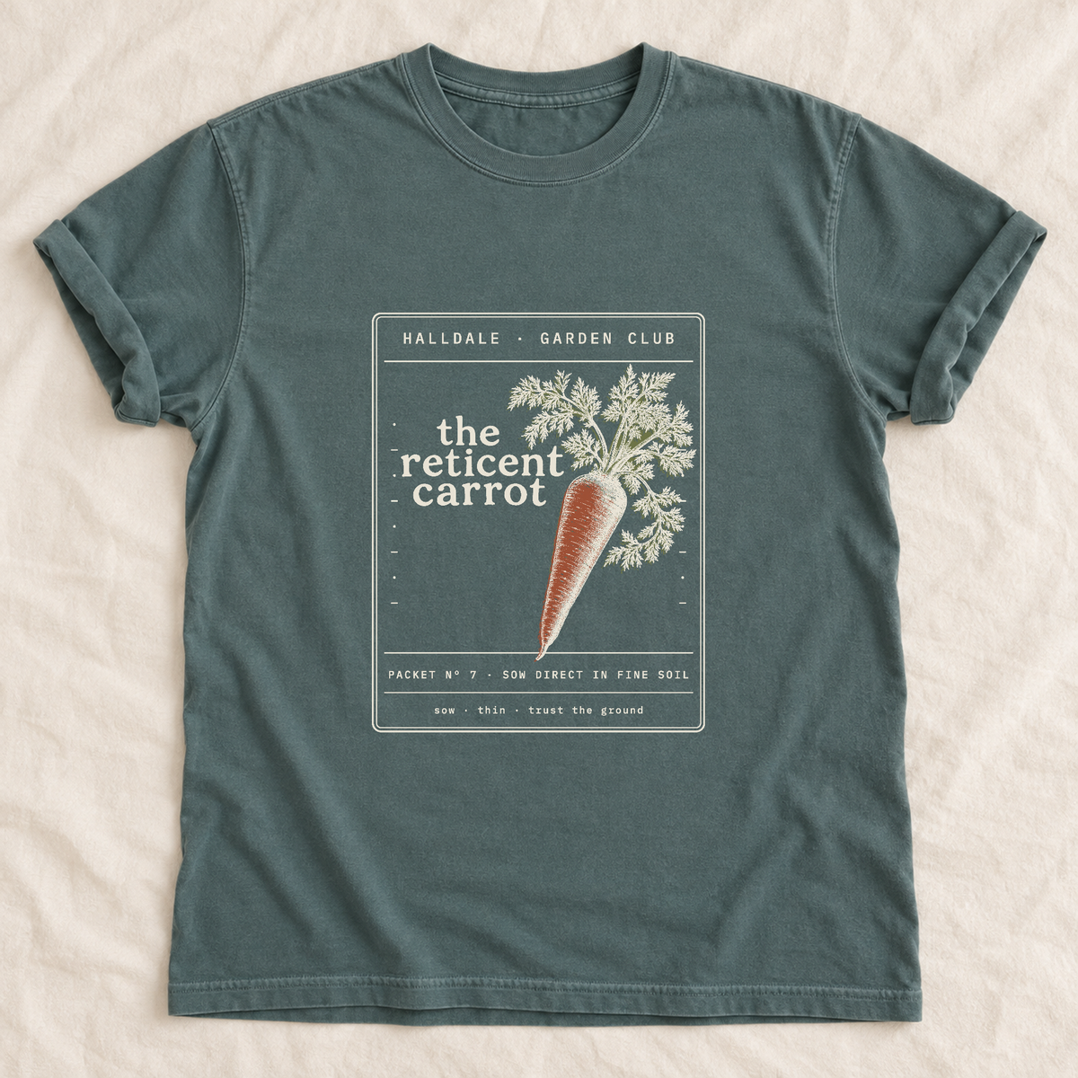 The Reticent Carrot tee in Blue Spruce, laid flat