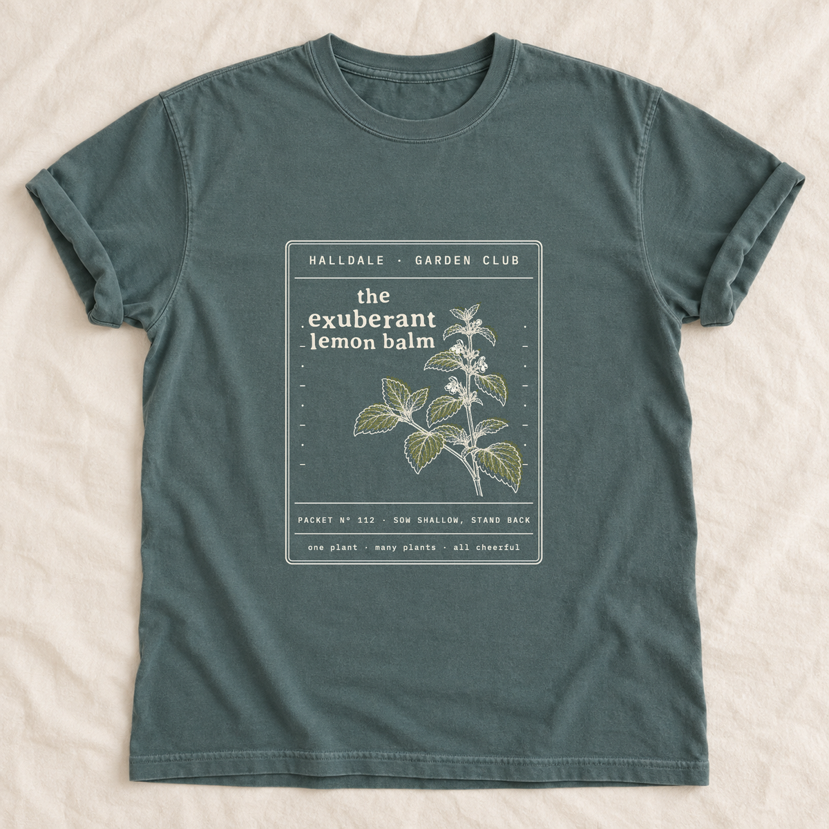 The Exuberant Lemon Balm tee in Blue Spruce, laid flat