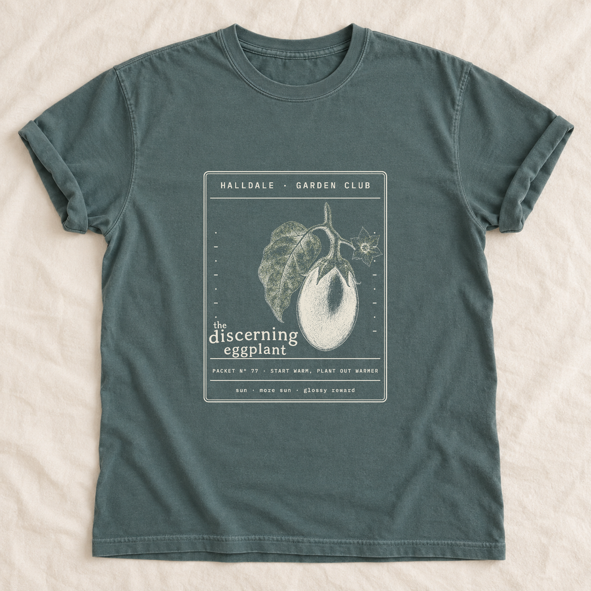 The Discerning Eggplant tee in Blue Spruce, laid flat