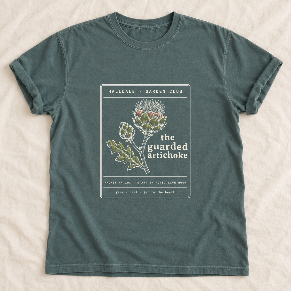 The Guarded Artichoke tee in Blue Spruce, laid flat