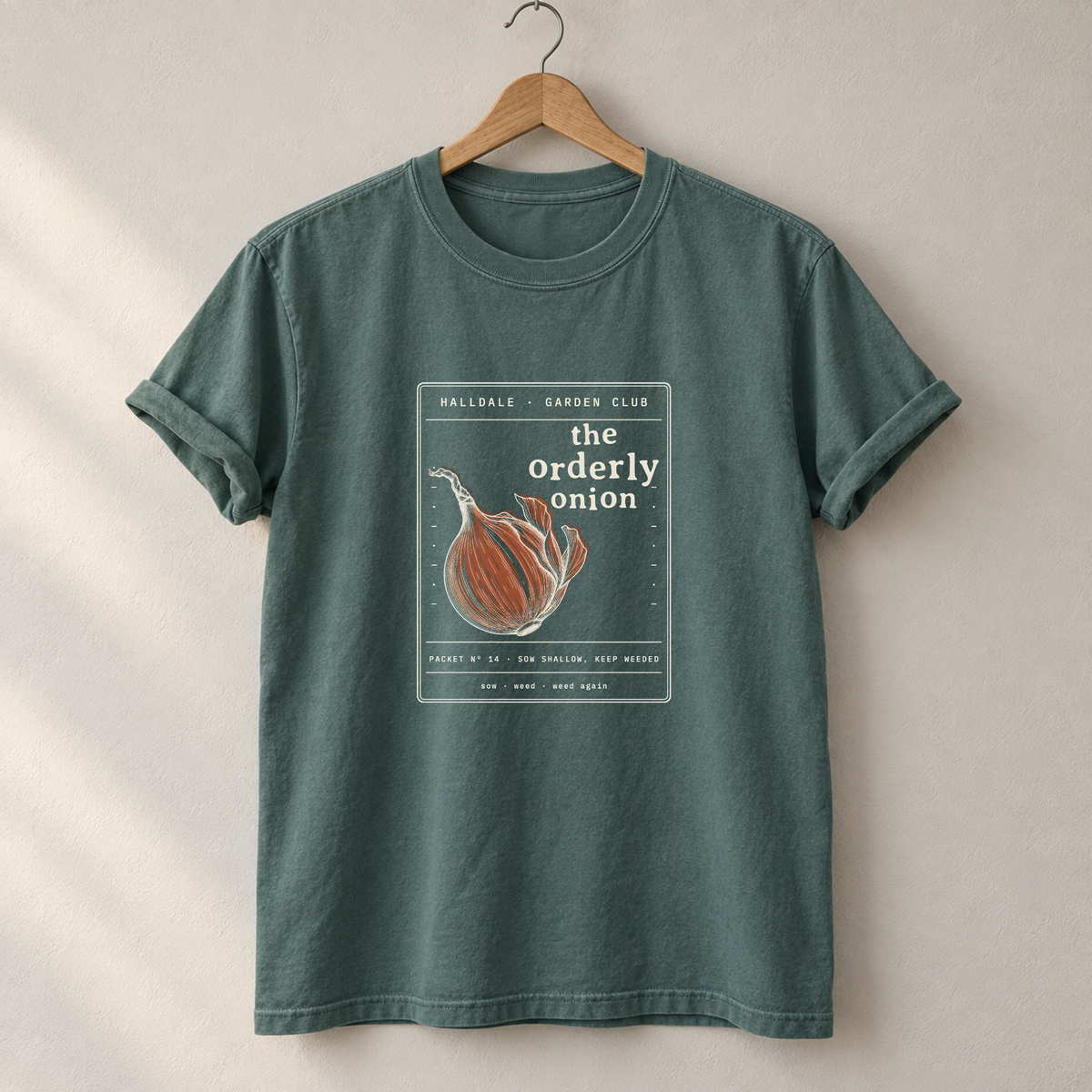 The Orderly Onion tee in Blue Spruce, on a hanger