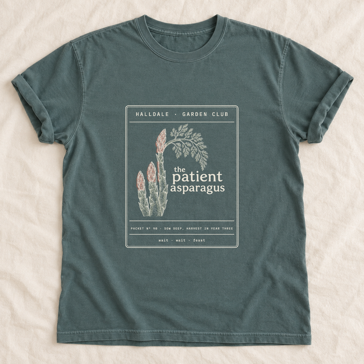 The Patient Asparagus tee in Blue Spruce, laid flat