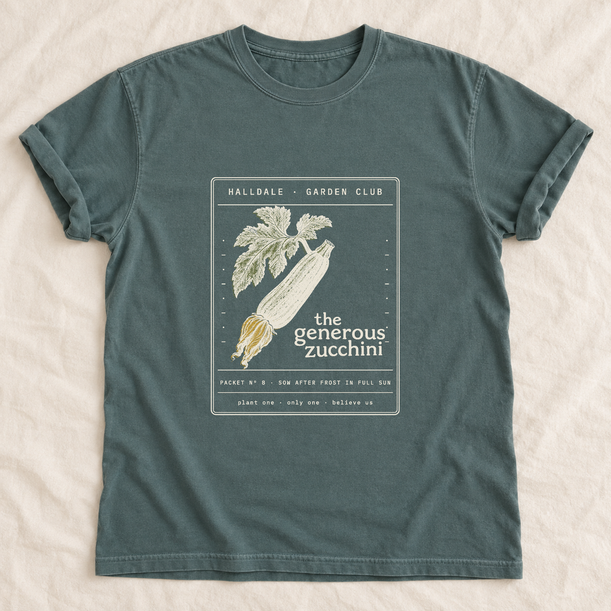 The Generous Zucchini tee in Blue Spruce, laid flat