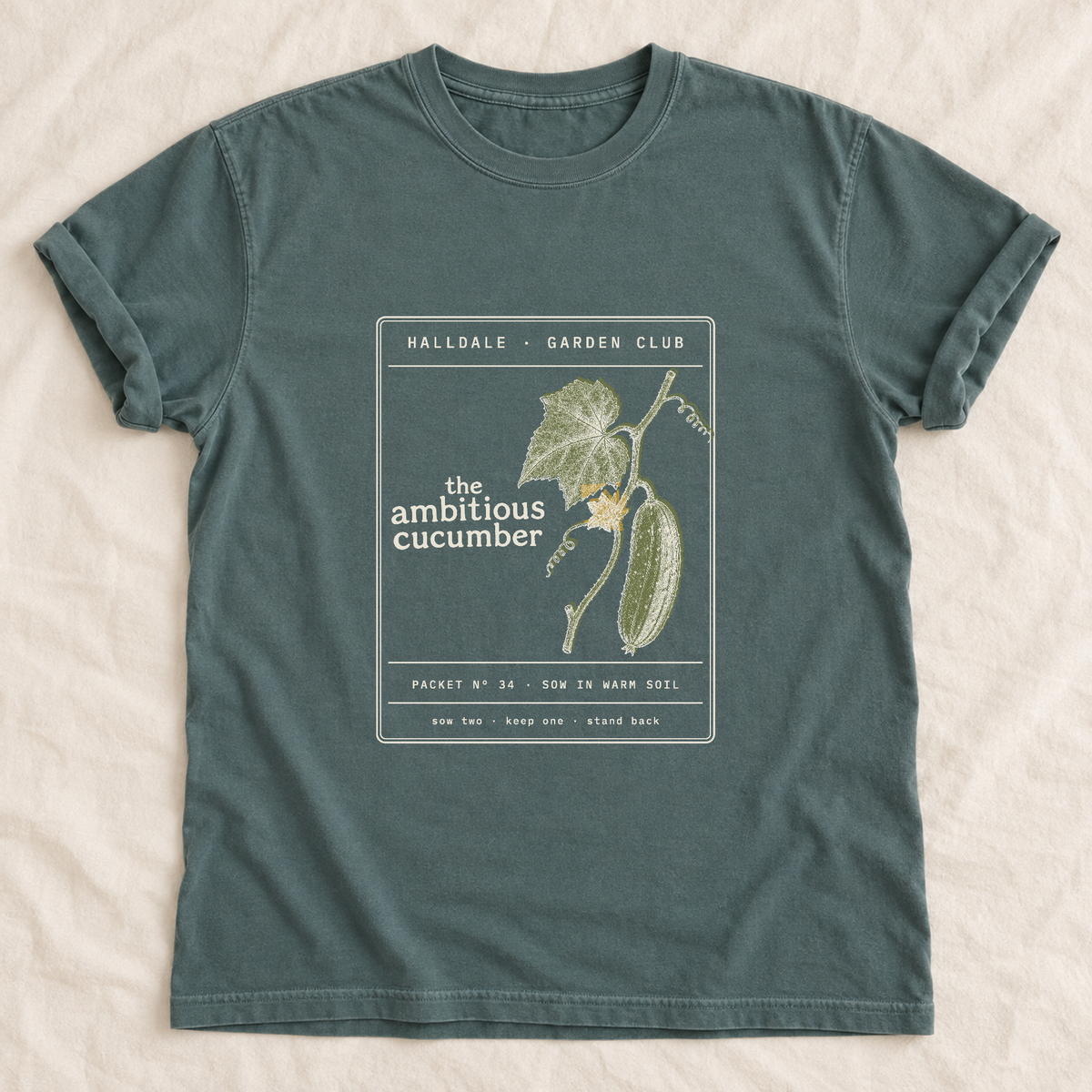 The Ambitious Cucumber tee in Blue Spruce, laid flat