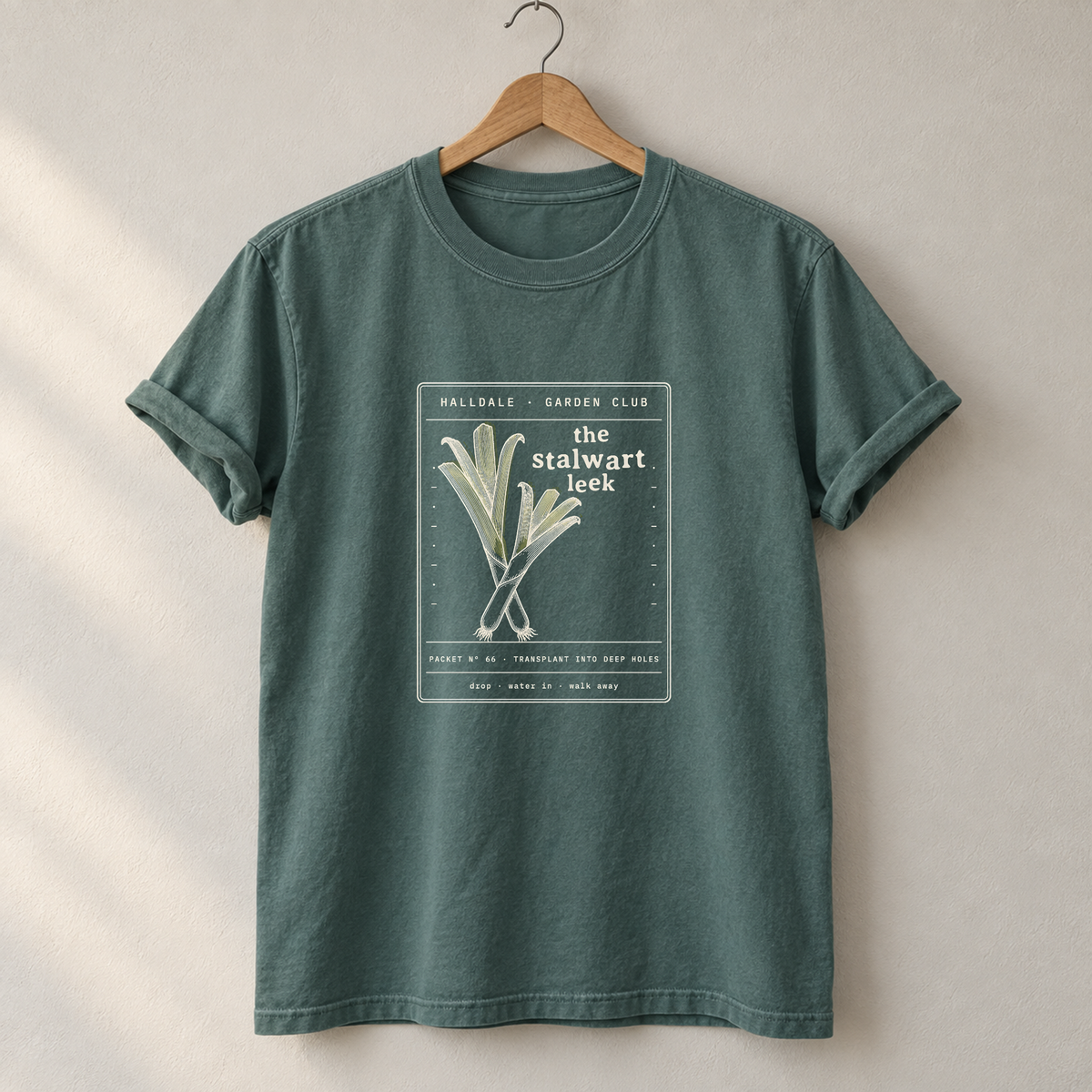 The Stalwart Leek tee in Blue Spruce, on a hanger