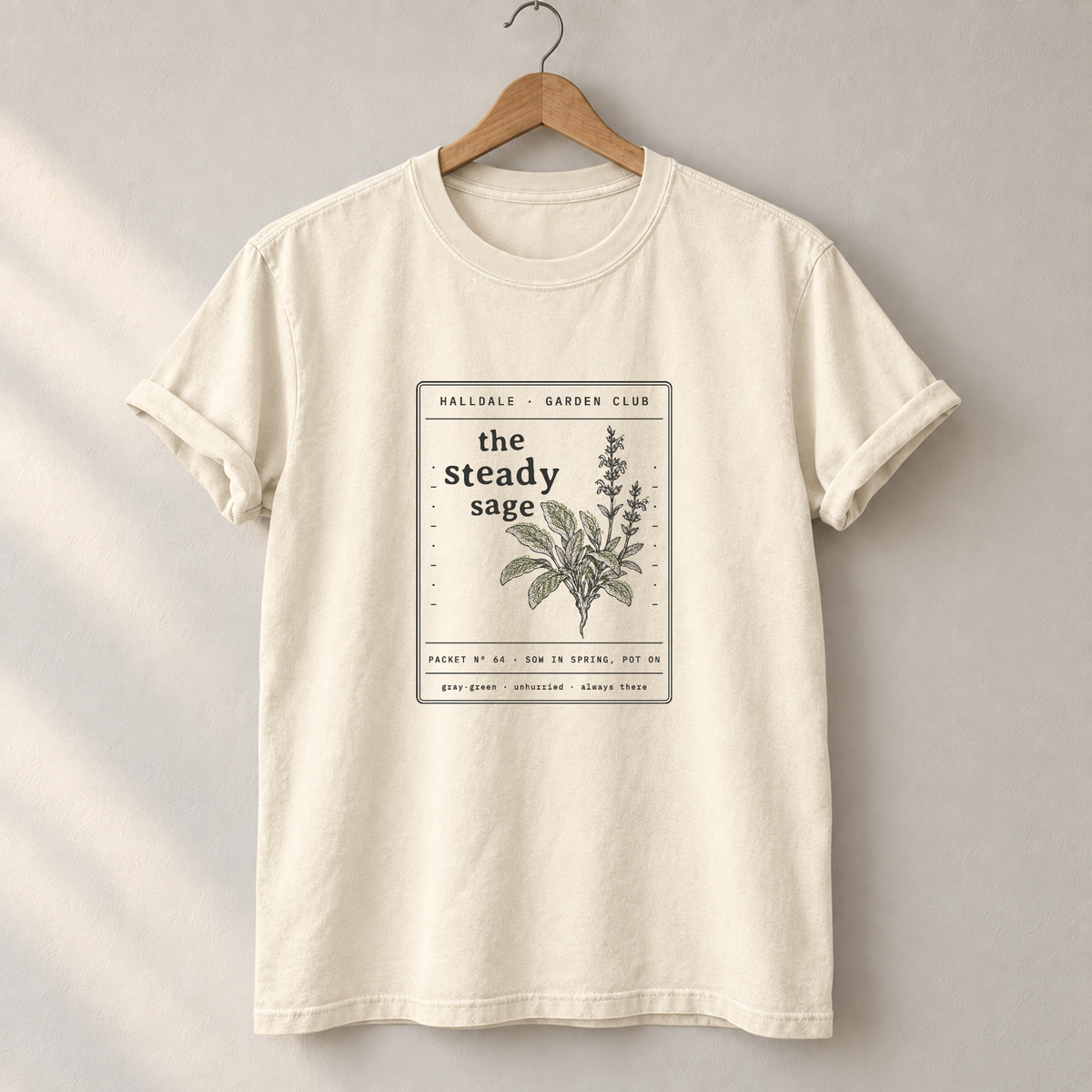The Steady Sage tee in Ivory, on a hanger
