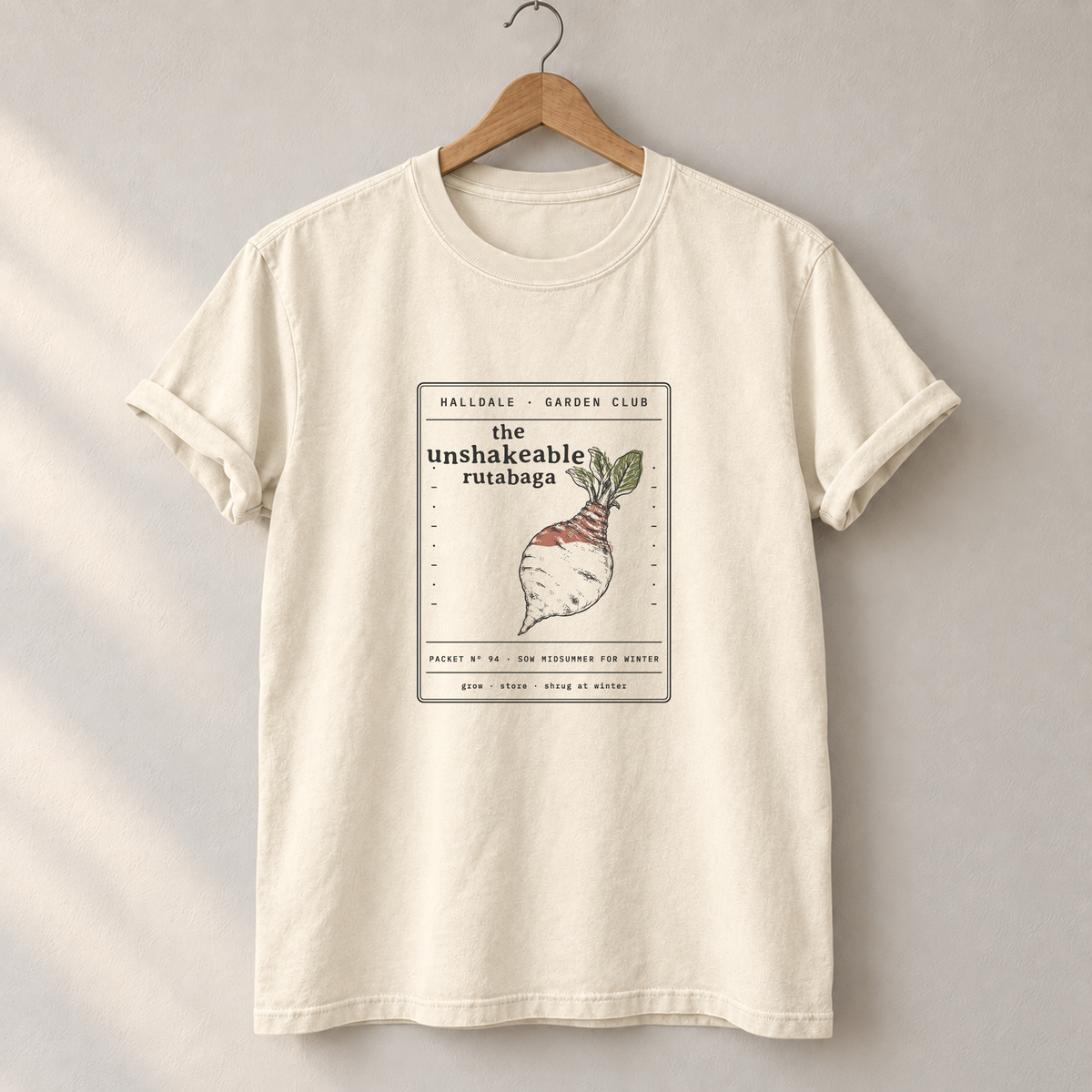 The Unshakeable Rutabaga tee in Ivory, on a hanger