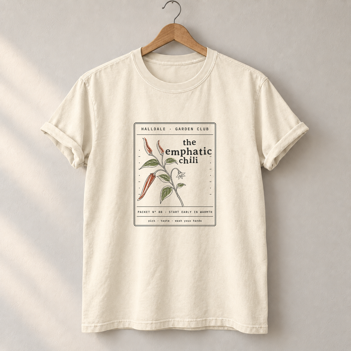 The Emphatic Chili tee in Ivory, on a hanger