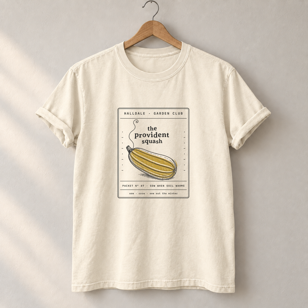 The Provident Squash tee in Ivory, on a hanger
