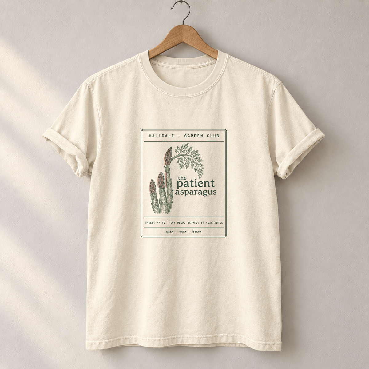 The Patient Asparagus tee in Ivory, on a hanger