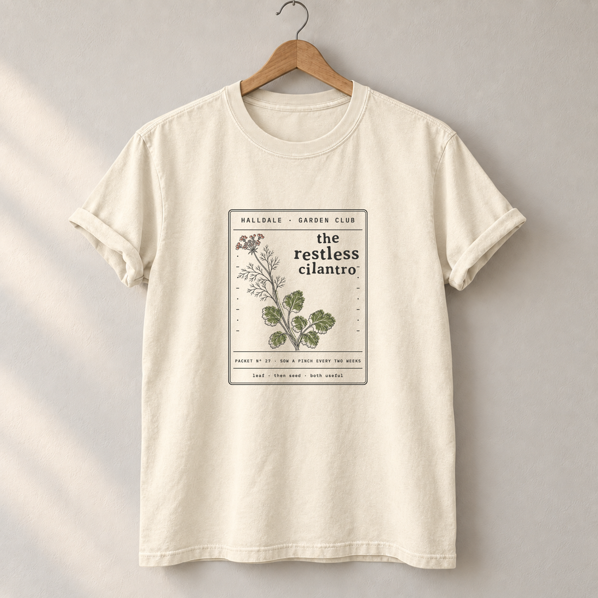 The Restless Cilantro tee in Ivory, on a hanger
