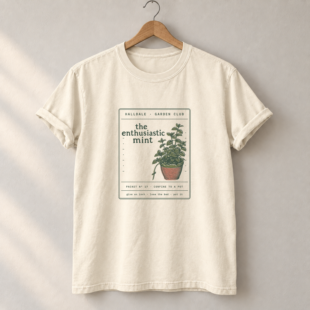 The Enthusiastic Mint tee in Ivory, on a hanger
