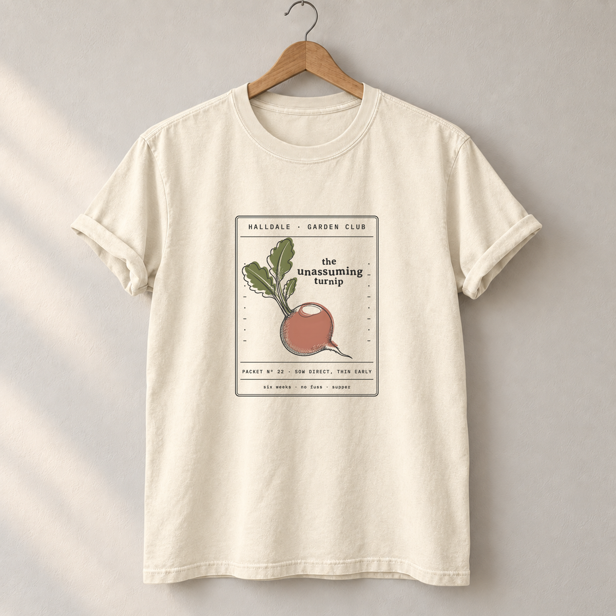 The Unassuming Turnip tee in Ivory, on a hanger