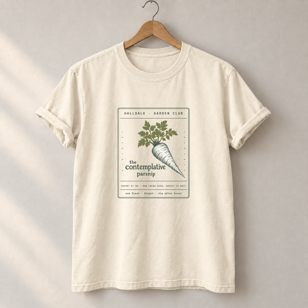 The Contemplative Parsnip tee in Ivory, on a hanger