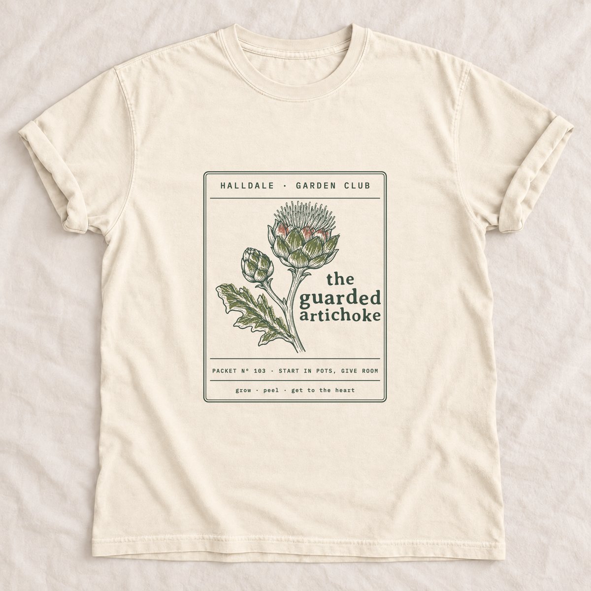 The Guarded Artichoke tee in Ivory, laid flat