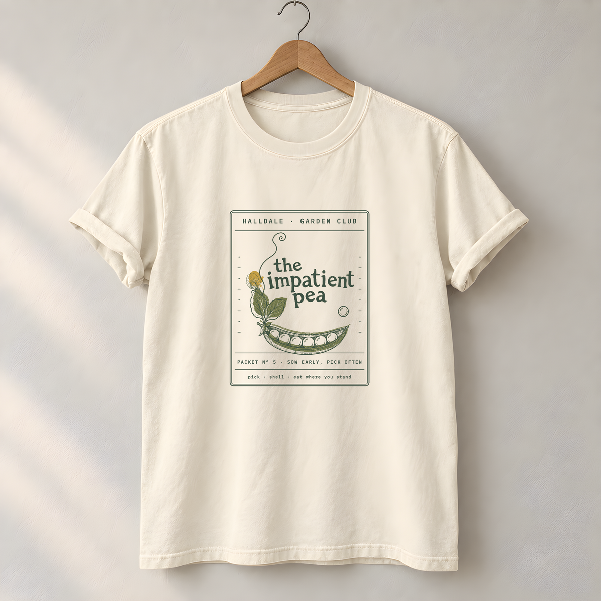The Impatient Pea tee in Ivory, on a hanger